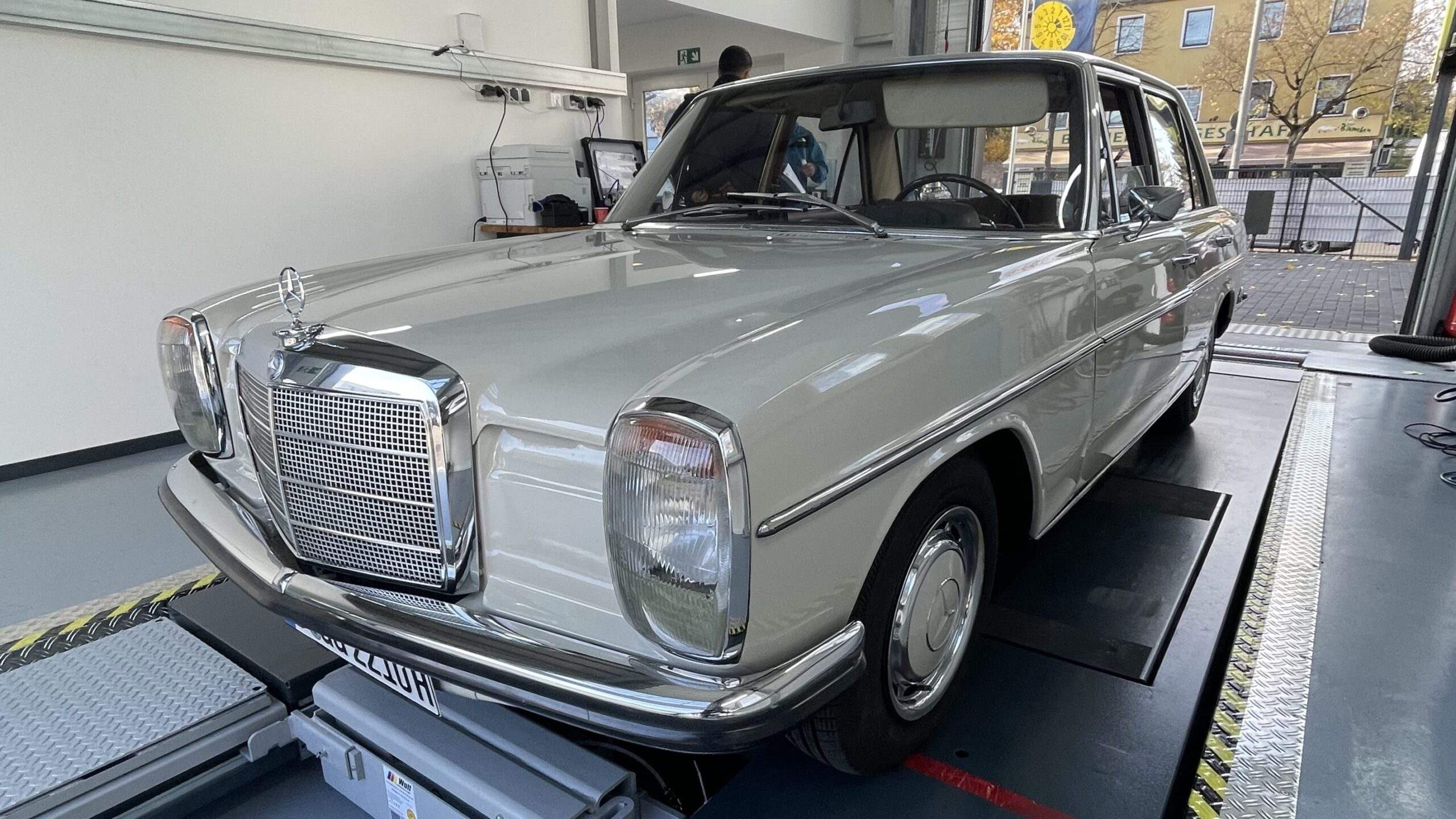 Silberner Mercedes-Benz Oldtimer auf Hebebühne in professioneller Werkstatt für H-Kennzeichen-Begutachtung
