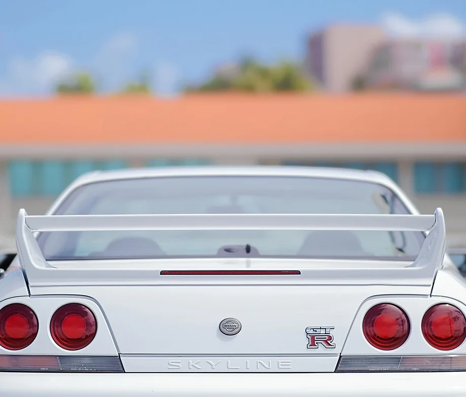 Weißer Nissan Skyline GT-R mit Heckspoiler - Beispiel für Fahrzeugmodifikationen