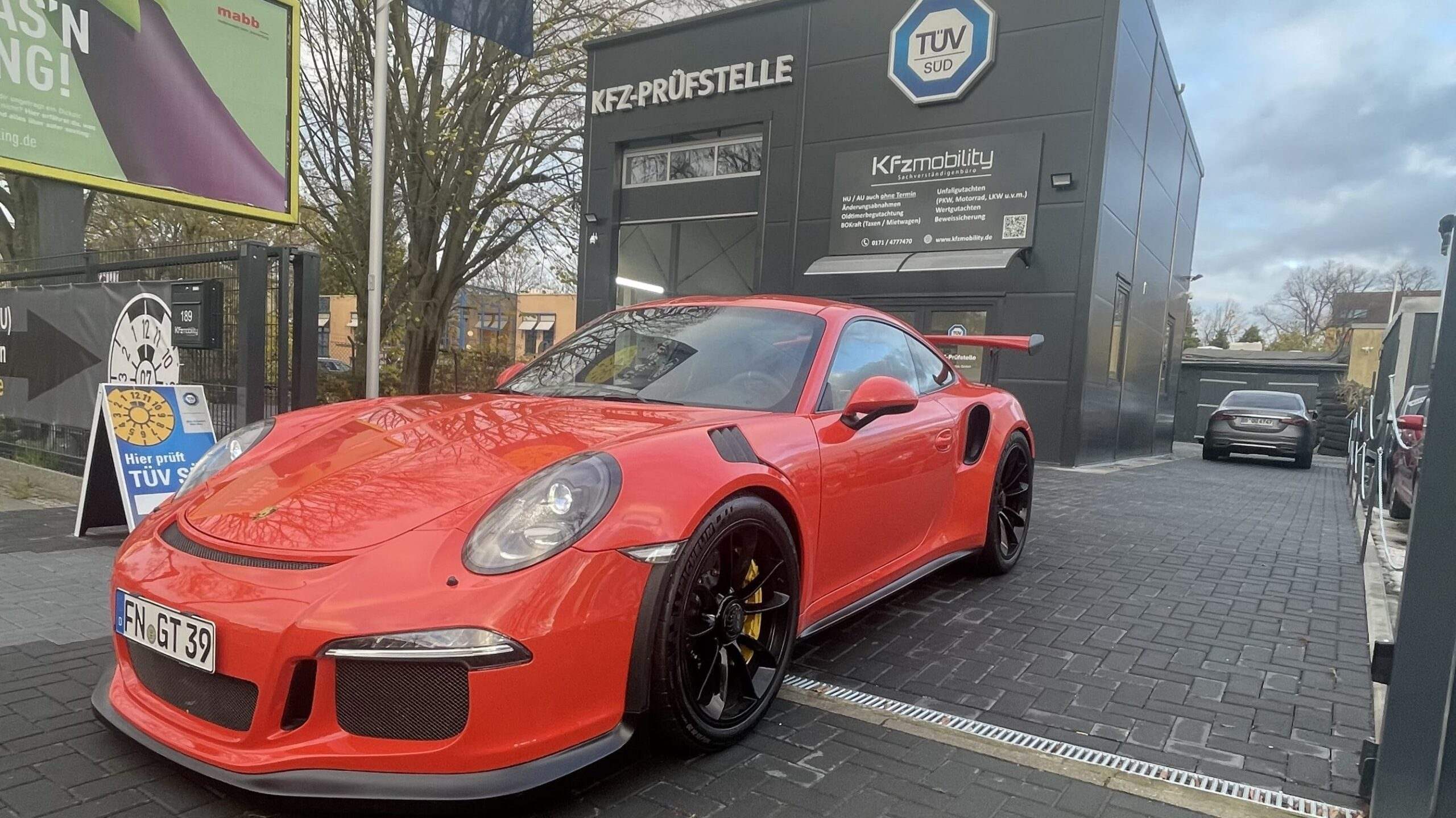 Roter Porsche 911 GT3 RS mit Tuning-Modifikationen vor der KFzmobility-Prüfstelle für Änderungsabnahme